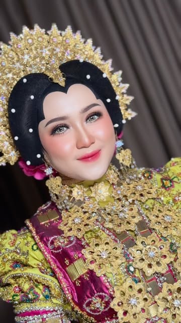 Riasan dengan sanggul Bugis dan baju hijau